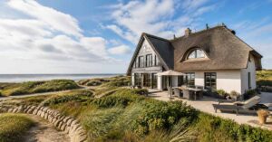 Ferienhaus mit Reetdach in Dünenlage am Meer – Symbolbild für den Verkauf einer Ferienimmobilie. | Immobilienverkauf